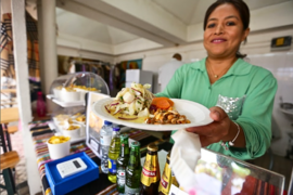 Food vendor at the Global Gathering, the person is showing their dish